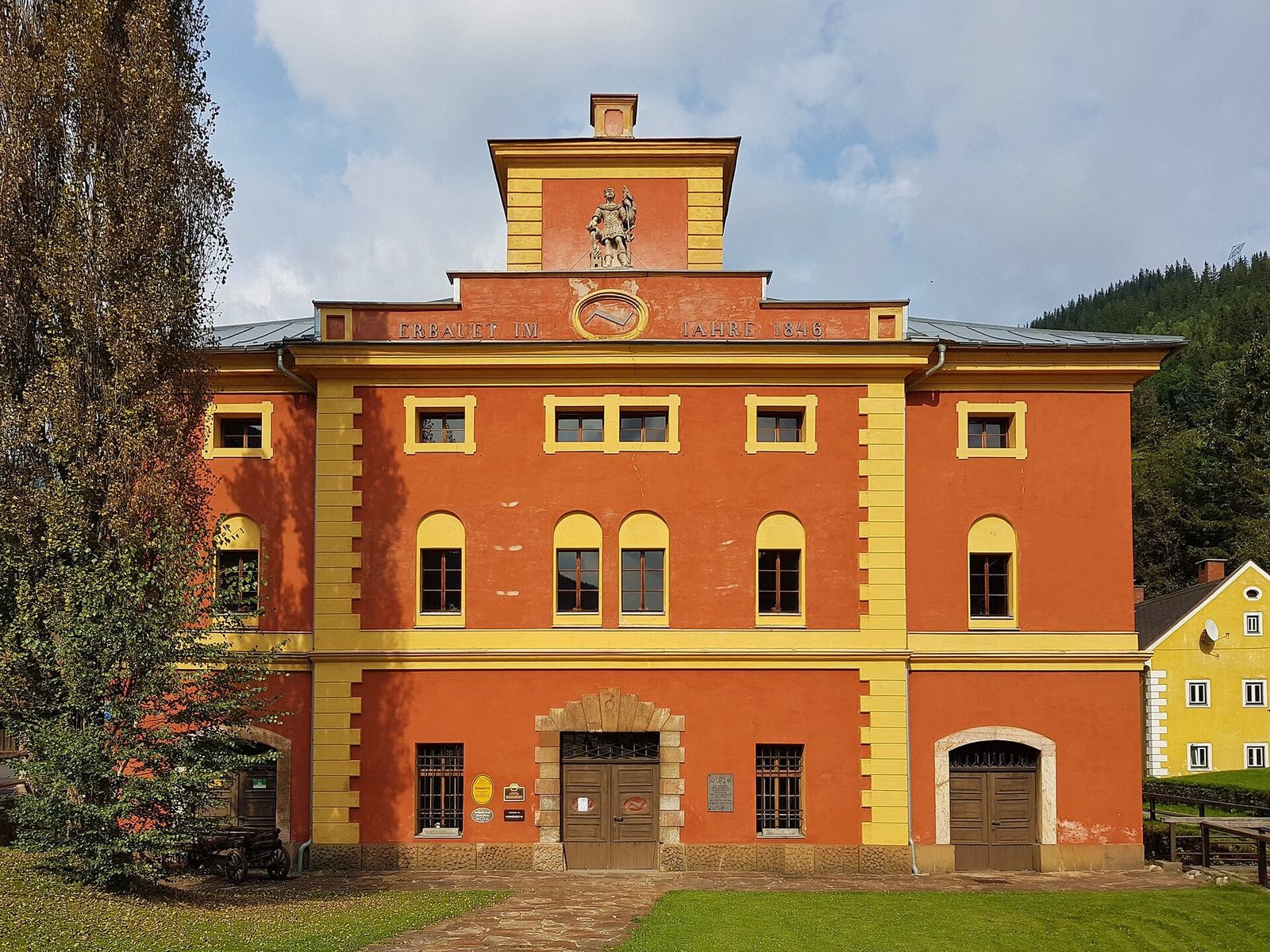 Die Südfassade des Radwerkes IV: rot gefasst mit ockergelber Gliederung, im Giebel die Inschrift ERBAUET IM IAHRE 1846